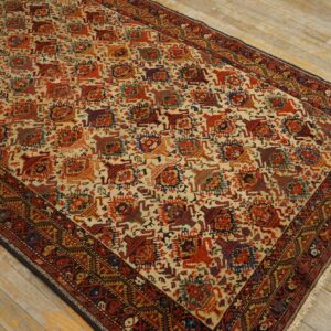 Traditional rug with cream background, repeating geometric red and blue animal motifs, displayed on light wood flooring.