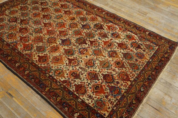 Traditional rug with cream background, repeating geometric red and blue animal motifs, displayed on light wood flooring.