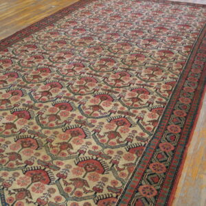 Long rug with repeating red, pink, blue, and tan stylized motifs on light wood floors.
