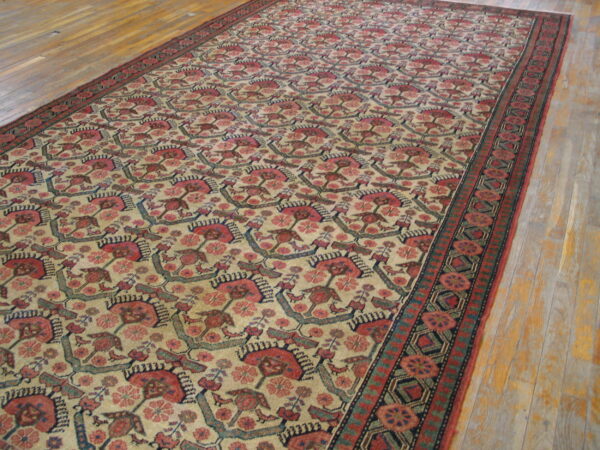 Long rug with repeating red, pink, blue, and tan stylized motifs on light wood floors.