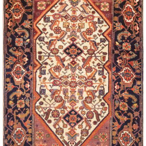 Traditional low-pile rug with stylized cream and navy geometric patterns, highlighted with rust and terracotta motifs.
