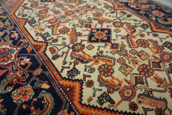 Detailed view of a low pile rug featuring tribal motifs in navy, cream, orange, and red.