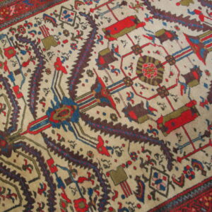 Geometric and stylized motifs in red, navy, brown, and olive green cover the cream-colored rug field.