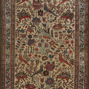 A traditional beige rug features stylized red and blue birds among intricate floral motifs and a dusty blue border.