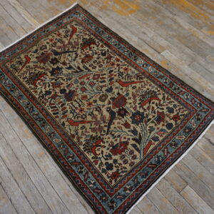 Traditional rug with a beige field, red and blue floral patterns, and bird motifs on distressed gray wood floors.