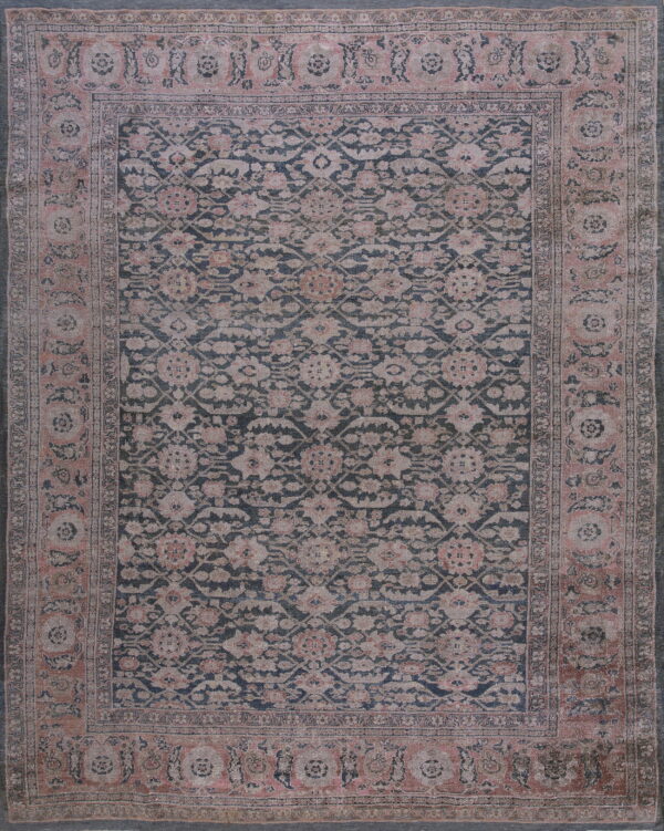 Distressed rug featuring a dark blue field with faded pink and beige floral motifs and a wide border.