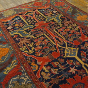 A traditional rug features a navy blue field with complex red, yellow, and blue patterns on light wooden floors.