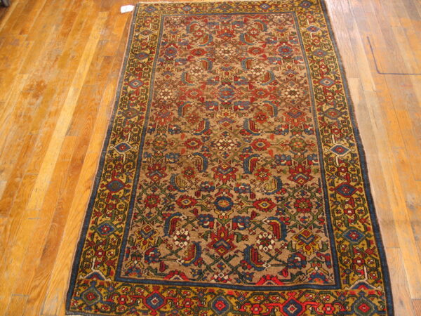 Traditional runner with dense red, blue, and gold patterns over a tan field on hardwood floors.