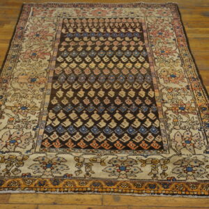 Geometric dark brown center field rug with a wide beige border featuring pink and blue flowers on wood flooring.