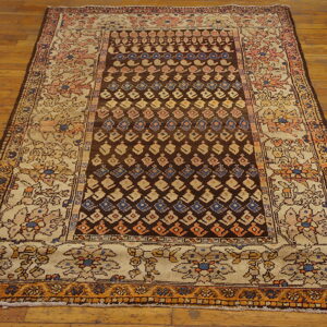 Dark brown and beige patterned rug with colorful geometric and floral designs lying on a wood floor.