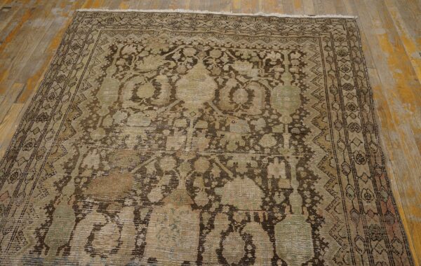 Heavily distressed low-pile rug with faded brown and sage traditional motifs on a rustic wood floor.