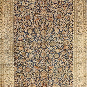 Detailed rug displaying a dense floral pattern in navy blue, beige, light blue, and rust colors.