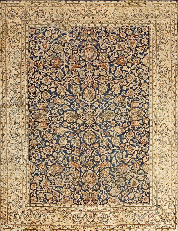 Detailed rug displaying a dense floral pattern in navy blue, beige, light blue, and rust colors.