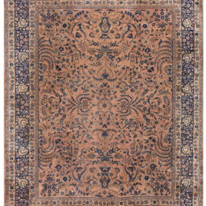 Low-pile rug featuring a terracotta pink field with navy blue intricate formal floral designs.