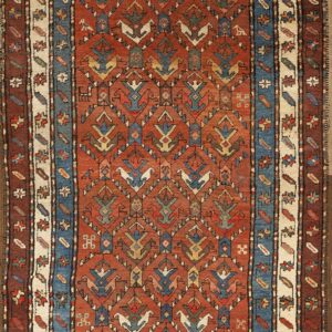 Terracotta runner with repeating geometric bird motifs and multi-layered borders in blue, cream, and brown.