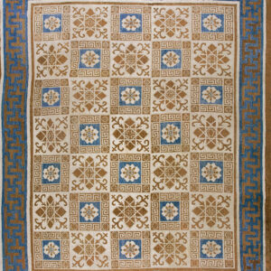 Blue and tan rug with a gridded field pattern and a Greek key outer border.