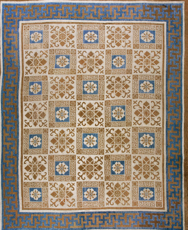 Blue and tan rug with a gridded field pattern and a greek key outer border.