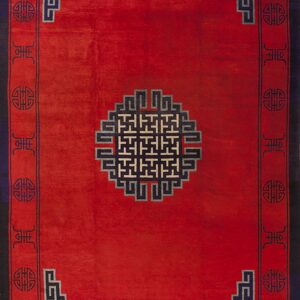 A red rug with a central fretwork medallion and geometric borders in navy blue and off-white accents.