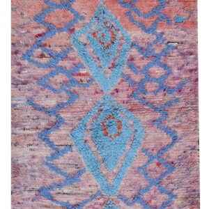 High pile rug with central blue diamonds and lattice design on a pink and purple mottled field.