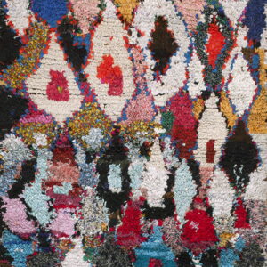 High-pile, shaggy rug with a multicolor geometric diamond pattern in red, blue, yellow, pink, and white.