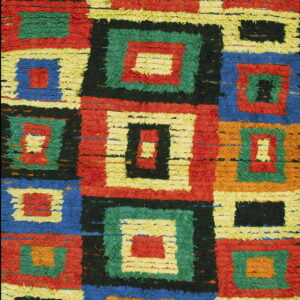 Textured, high-pile rug detail showing geometric blocks of red, blue, green, yellow, orange, and black.