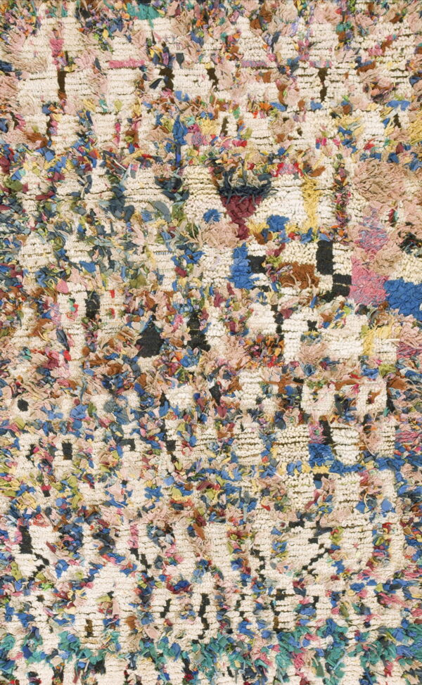 Highly textured shag rug in cream with multicolor fabric strips creating an abstract grid pattern.