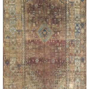 Faded red and tan rectangular rug with intricate geometric tribal patterns and a central blue diamond medallion.
