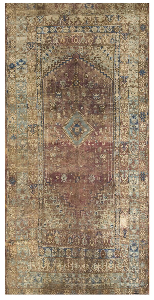 Faded red and tan rectangular rug with intricate geometric tribal patterns and a central blue diamond medallion.