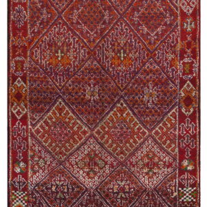Red, orange, and purple rug featuring a field of interlocking geometric diamonds and intricate borders.