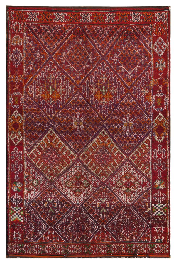 Red, orange, and purple rug featuring a field of interlocking geometric diamonds and intricate borders.