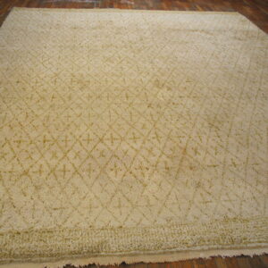 Light cream shag rug featuring a subtle tonal diamond and cross pattern on dark hardwood.