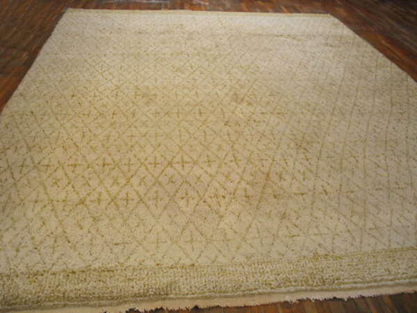 Light cream shag rug featuring a subtle tonal diamond and cross pattern on dark hardwood.