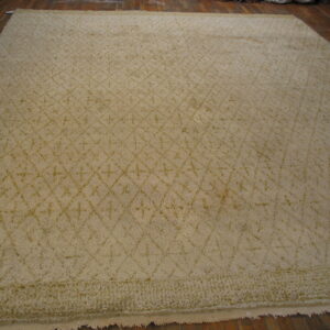A large cream shag rug featuring a subtle diamond trellis pattern lies on dark wooden plank floors.