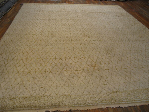 A large cream shag rug featuring a subtle diamond trellis pattern lies on dark wooden plank floors.