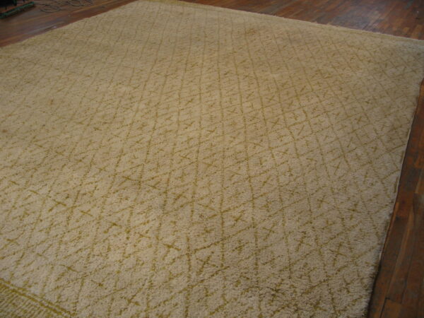 High pile beige rug with a subtle yellow-green diamond pattern on dark hardwood.