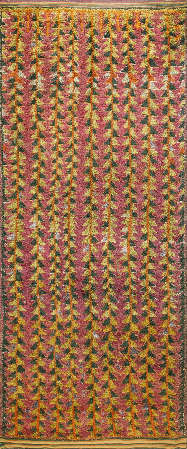Shaggy high-pile rug with vertical rows of green and yellow triangles on a magenta and orange field.