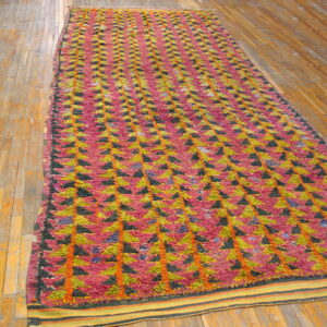 Long, textured runner with repeating pink, green, and black triangles on light hardwood floors.