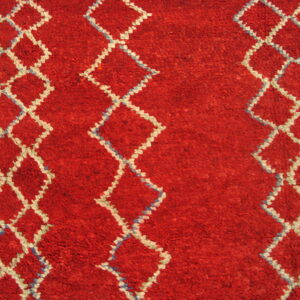 A textured red rug has white diamond patterns accented with light blue stitches.