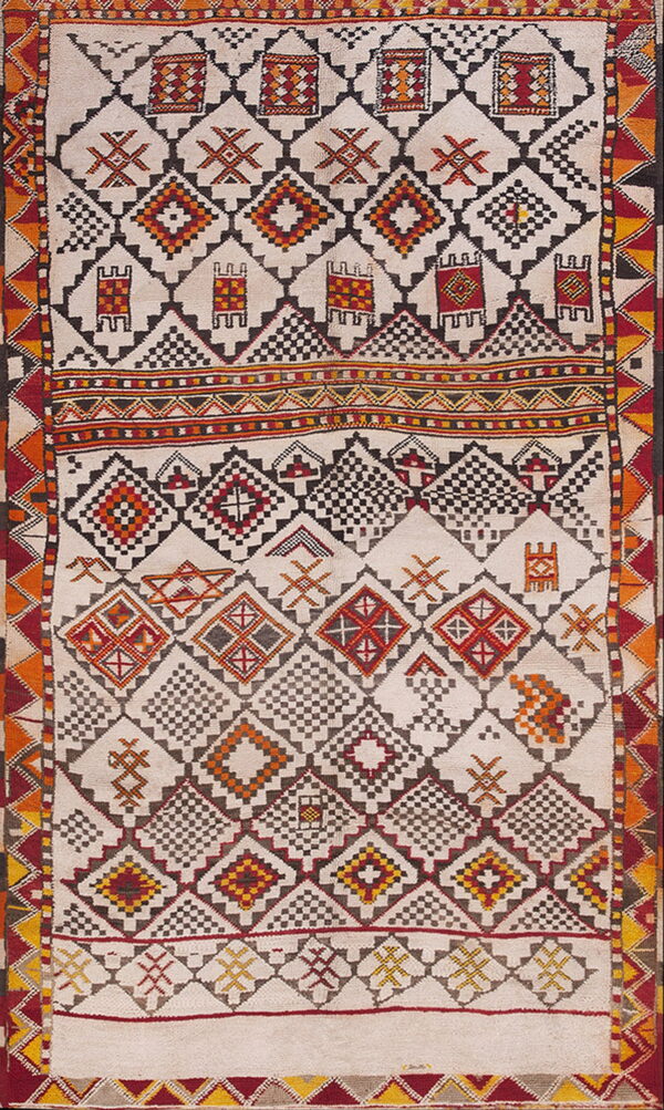 Geometric cream rug featuring complex diamond and stepped patterns bordered in red, black, and yellow.