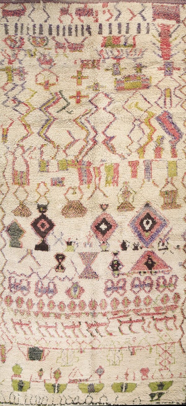 High-pile cream rug with asymmetrical geometric patterns in pink, purple, olive, and dark brown colors.