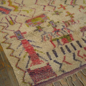 Shaggy off-white rug displaying abstract geometric patterns in pink, purple, and olive green on wood floor.