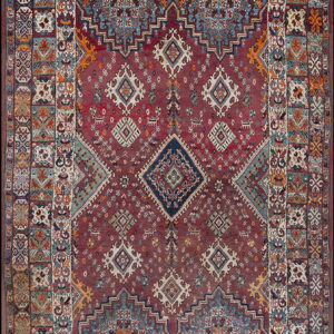 Traditional tribal rug with a maroon field, central diamonds, and wide borders featuring diverse geometric patterns.