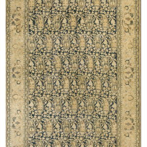 Navy blue rug with beige vertical paisley motifs and a wide, ornate tan border design.