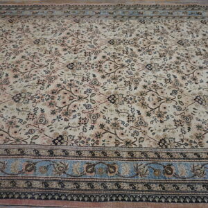Cream rug with dense scrolling floral pattern and contrasting light blue and dark brown borders.