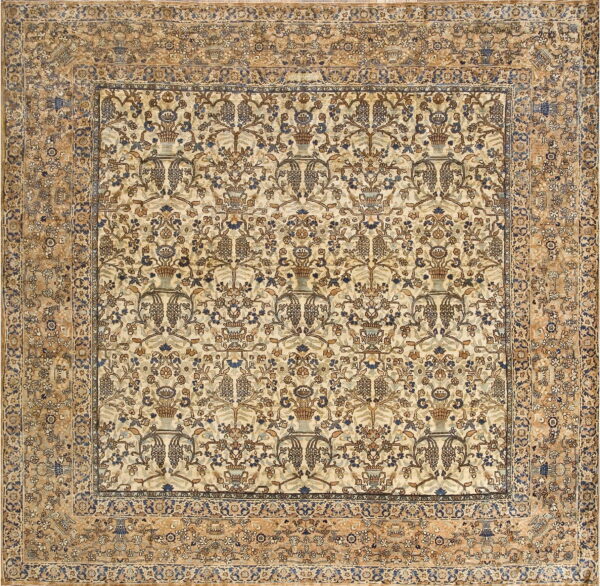 Detailed rug featuring a cream field with blue and brown vines, surrounded by a wide tan floral border.