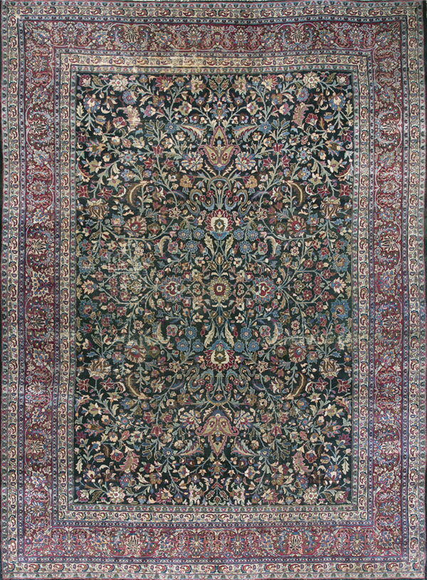 Dark teal rug with intricate red, blue, and gold floral patterns and a wide multi-banded border.