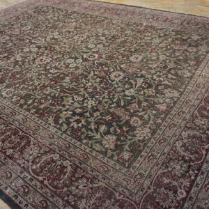 Large square rug with dark green and burgundy traditional floral pattern on rustic wood floor.
