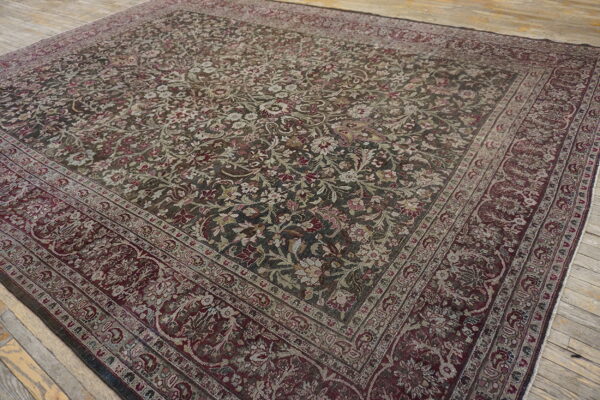 Large square rug with dark green and burgundy traditional floral pattern on rustic wood floor.