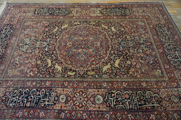 Low-pile, elaborate navy and burgundy area rug featuring animal figures and intricate scripted borders.