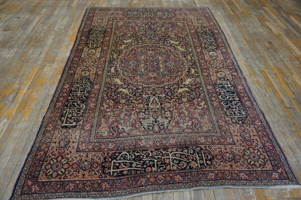 Ornate navy, red, and tan medallion rug with detailed animal motifs and calligraphy borders on distressed wood floors.